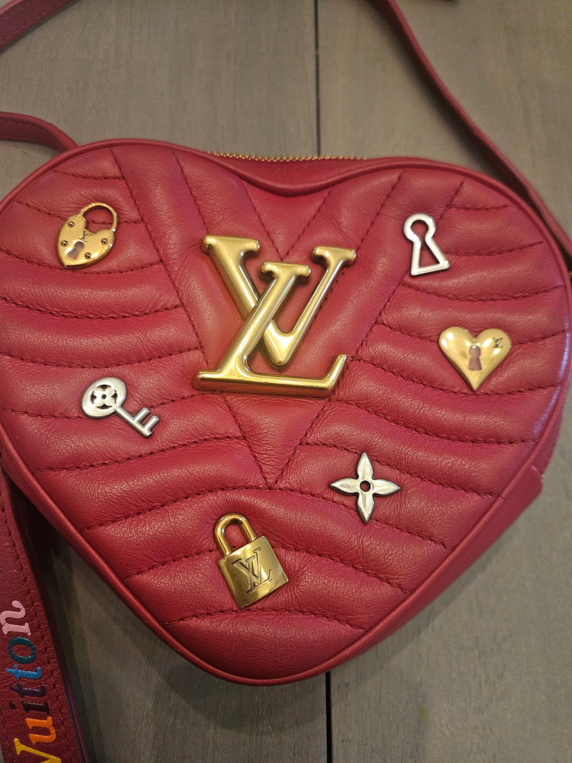 Front close-up of red quilted heart handbag and gold LV hardware