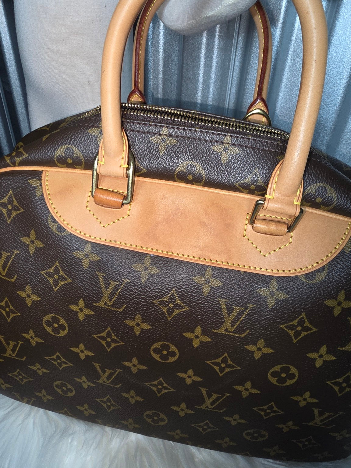 Angled view of monogram canvas and leather handles
